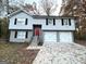 Two-story house with gray siding, red door, and three-car garage at 55 Stone Creek Dr, Covington, GA 30016