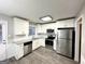 Modern kitchen with white cabinets, stainless steel appliances, and gray countertops at 55 Stone Creek Dr, Covington, GA 30016