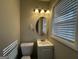 Simple bathroom with white vanity, toilet, and an oval mirror at 2057 Sombrero Se Way, Atlanta, GA 30316