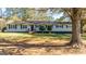 Ranch style home with beige siding, black window trim, and mature tree at 308 Lee Thompson Rd, Moreland, GA 30259