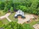 Barn-style home with a gravel driveway surrounded by lush greenery at 238 Indian Creek Rd, Locust Grove, GA 30248