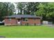 Brick ranch house with a well-maintained lawn and a spacious yard at 126 E Mimosa Dr, Jonesboro, GA 30236