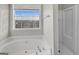 Relax in this garden tub with shower, large window and tile flooring at 231 Ferguson Ave, Locust Grove, GA 30248
