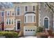 Inviting townhome showcasing a brick stairway, arched entryway, with a one-car garage and manicured bushes at 3863 Meeting St, Duluth, GA 30096