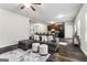 Open concept living room featuring a gray sofa, white ottomans, and dark wood floors at 4499 Lombard Rd, Ellenwood, GA 30294