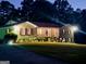 Brick ranch house with covered porch, lit at night at 787 Pine Needle Rd, Hampton, GA 30228