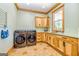 Laundry room with modern appliances, wood cabinets, and hexagon tile floor at 242 Kirkley Rd, Tyrone, GA 30290