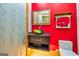 Stylish powder room features a green glass vessel sink and red walls at 242 Kirkley Rd, Tyrone, GA 30290