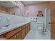 Bathroom with pink floral wallpaper, white tiled walls, and a single vanity at 320 Bates Ave, Fayetteville, GA 30215