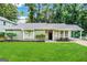 Ranch style home with gray siding, landscaped lawn, and covered patio at 2312 Leslie Brook Dr, Decatur, GA 30035