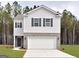 Two-story house with gray siding, white garage door, and landscaping at 11879 Aukerman Way # 128, Hampton, GA 30228