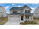 Two-story brick home with a large front yard and attached two-car garage at 1705 Goodwin Dr, Hampton, GA 30228