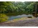 Serene pond with a stone feature and a gravel shore at 320 Massengale Rd, Brooks, GA 30205