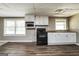 Efficient kitchen with white cabinets, black appliances, and vinyl flooring at 3306 Old Covington Hwy, Covington, GA 30014