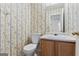 Small bathroom with toilet, sink, and floral wallpaper at 453 Camp Hill Ln, Jonesboro, GA 30238