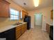 Galley kitchen with wood cabinets, black appliances, and tiled floor at 6195 Winston Trce, Mcdonough, GA 30252