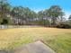 Large backyard with a patio, wooden fence and mature trees at 1010 Butterfly Cove Way, Locust Grove, GA 30248