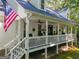 Farmhouse exterior with a wraparound porch and American flag at 313 Dingler Rd, Moreland, GA 30259