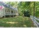 White house with wrap-around porch, large yard, and white fence at 313 Dingler Rd, Moreland, GA 30259