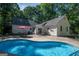 Relaxing kidney-shaped pool surrounded by patio and lush greenery at 313 Dingler Rd, Moreland, GA 30259