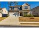 Two-story home with a light gray and brick exterior, two-car garage, and a landscaped yard at 413 Kinross Ln, Peachtree City, GA 30269