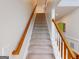 Carpeted staircase with wooden handrail at 6383 Edgewater Cv, Fairburn, GA 30213