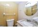 Bathroom featuring tiled walls, round mirror, toilet, and vanity at 6187 Deans Way, Morrow, GA 30260