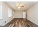 Bright living room with wood-look flooring, a ceiling fan, and access to stairs at 6187 Deans Way, Morrow, GA 30260