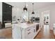 Modern kitchen with quartz island, stainless appliances, and open concept design to living area at 3920 Clifton Hill Ct, Cumming, GA 30040