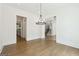 Open-concept living area with hardwood floors, a staircase, and elegant light fixtures, perfect for entertaining at 3920 Clifton Hill Ct, Cumming, GA 30040