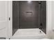 Bathroom with a black herringbone tiled shower with a built-in niche and black hardware at 3920 Clifton Hill Ct, Cumming, GA 30040