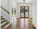 Bright foyer showcasing hardwood floors, a staircase, and large windows offering scenic outdoor views at 3920 Clifton Hill Ct, Cumming, GA 30040