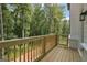 Wooden deck with railing overlooking a lush green wooded area and a white house exterior at 3920 Clifton Hill Ct, Cumming, GA 30040