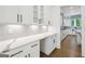 Stylish kitchen area features white cabinetry, quartz countertops, and gray tile backsplash at 3920 Clifton Hill Ct, Cumming, GA 30040