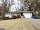 Single-story home with white brick exterior, attached garage, and a driveway leading to the entrance at 2830 Battle Forrest Dr, Decatur, GA 30034