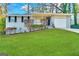 Charming single-story home with a white brick exterior, attached garage, and lush green lawn at 2830 Battle Forrest Dr, Decatur, GA 30034