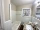Clean and simple bathroom with tiled walls, vanity, and a tub/shower combo at 2003 Rosewood Rd, Decatur, GA 30032