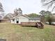 Backyard with wooden deck, grassy lawn, and trees at 464 Stonewood Dr, Stone Mountain, GA 30087