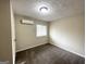 Empty bedroom with carpeted floors, window, and wall-mounted AC unit at 464 Stonewood Dr, Stone Mountain, GA 30087