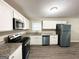 Modern kitchen featuring white cabinets, stainless steel appliances, granite countertops, and wood-look flooring at 464 Stonewood Dr, Stone Mountain, GA 30087