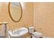 Powder room with pedestal sink, gold fixtures, and decorative wallpaper at 110 Madison Ave, Peachtree City, GA 30269