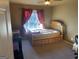 Bedroom with wooden bed frame, window, red curtains, and carpeted floor at 3003 Canter Way, Duluth, GA 30097