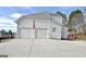 Two-car garage with large doors and a concrete driveway at 121 Lexington Pass, Peachtree City, GA 30269