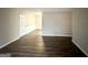 Spacious, empty living room with wood-look flooring, white walls, and a door leading to another room at 1519 Pine Glen Cir, Decatur, GA 30035