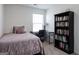 A bedroom featuring a bed, desk, bookcase, and window at 1304 Speckle Park Way, Stockbridge, GA 30281