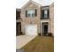 Attractive townhome exterior with a one-car garage and brick facade at 1304 Speckle Park Way, Stockbridge, GA 30281