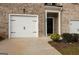 Close-up of the townhome's front exterior showcasing the brick facade and garage at 1304 Speckle Park Way, Stockbridge, GA 30281