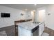 Kitchen island with granite countertop, sink, and dishwasher, open to the dining and living areas at 1304 Speckle Park Way, Stockbridge, GA 30281