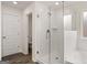 Bright bathroom with a glass shower, white tile, and wood-look floor at 671 Edgar St, Hampton, GA 30228