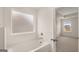 Modern bathroom with soaking tub, tile surround, and large window at 671 Edgar St, Hampton, GA 30228